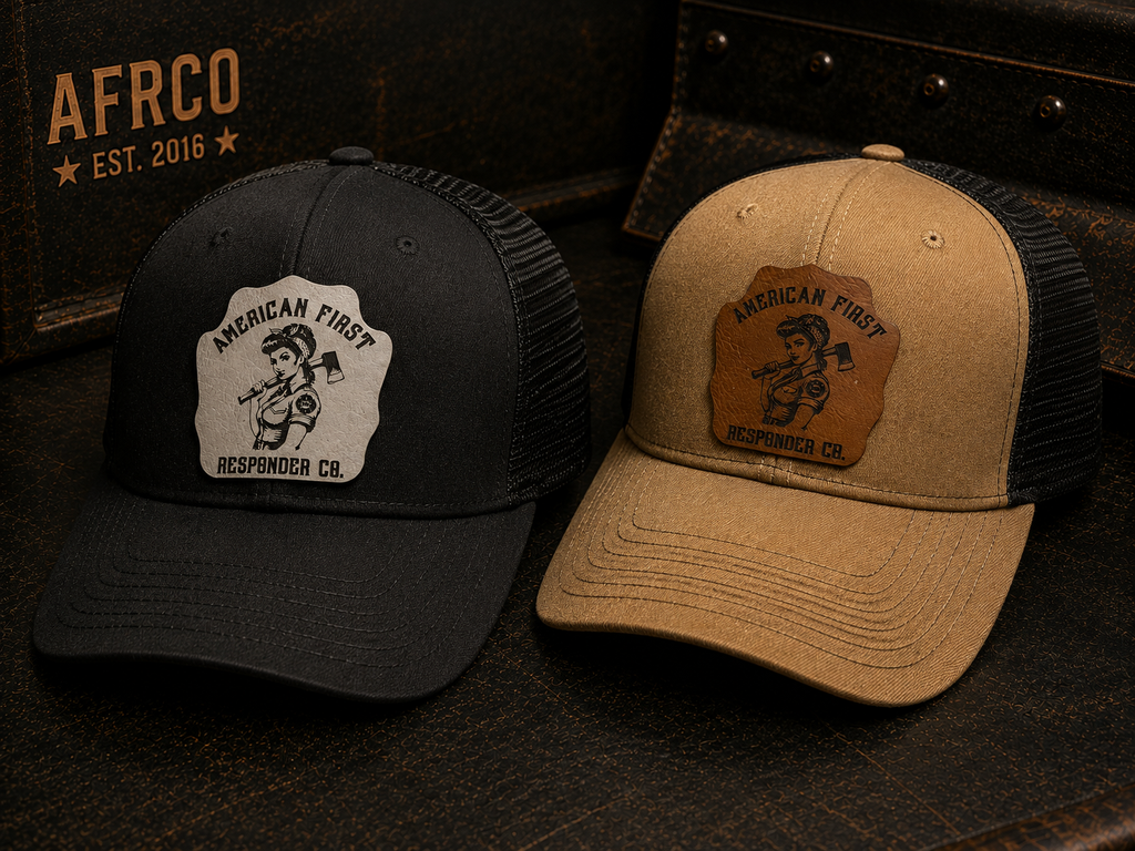 Two trucker-style caps displayed side by side on a dark textured surface. The left cap is black with a white patch reading 'American First Response Co.