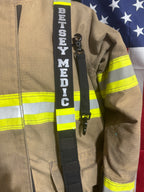 Personalized reflective firefighter radio strap attached to turnout gear, showing real-world fit and professional appearance.