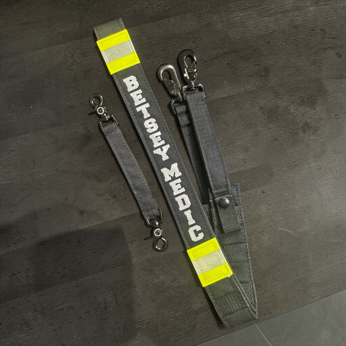 Personalized firefighter radio strap with silver reflective name, matching reflective trim, heavy-duty hardware, and webbing anti-sway strap by American First Responder Co.