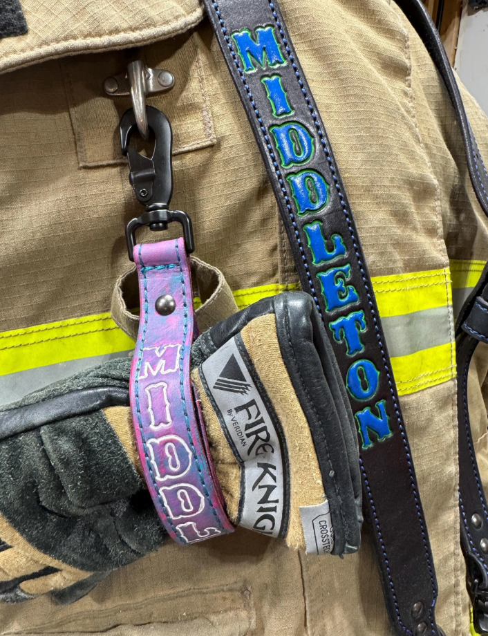 Personalized cotton candy firefighter glove strap attached to structural firefighting gloves.