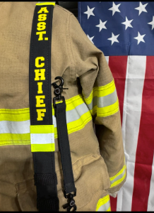 Personalized reflective trim firefighter radio strap attached to firefighter turnout gear during everyday use.