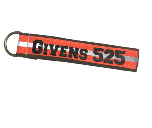Flat custom firefighter keychain made from cotton ripstop fabric with reflective ribbon, brass D-ring, and personalized heat-pressed vinyl name.