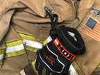 Close up of Personalized firefighter webbing glove strap with orange reflective name, heavy-duty hardware, and structural firefighting gloves.