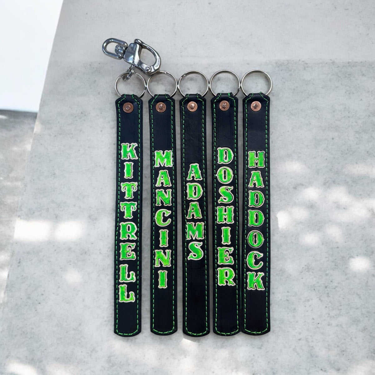 Custom glow-in-the-dark leather SCBA quick release pulls with heavy-duty swivel snap and key ring hardware for firefighter turnout gear.