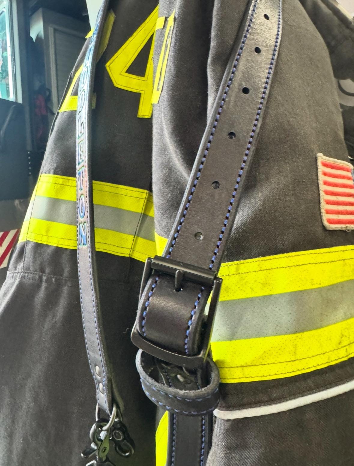 Black leather firefighter radio strap with radio holster attached