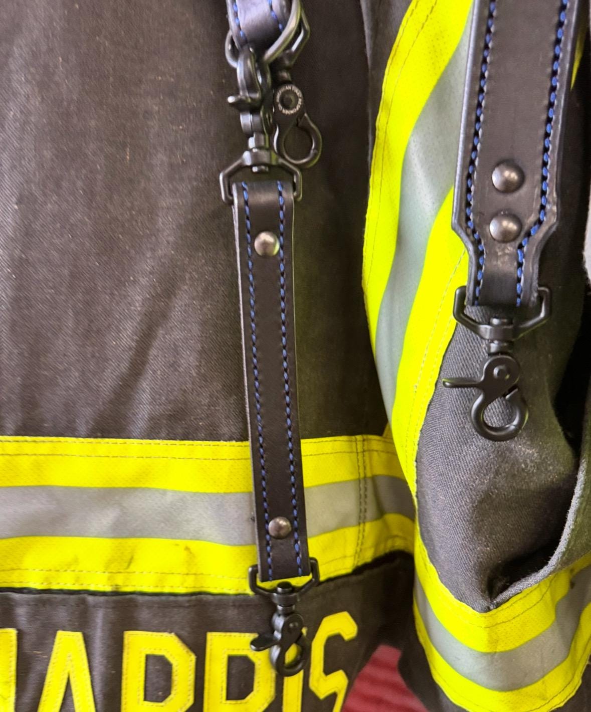 Black leather firefighter radio strap showing heavy-duty hardware